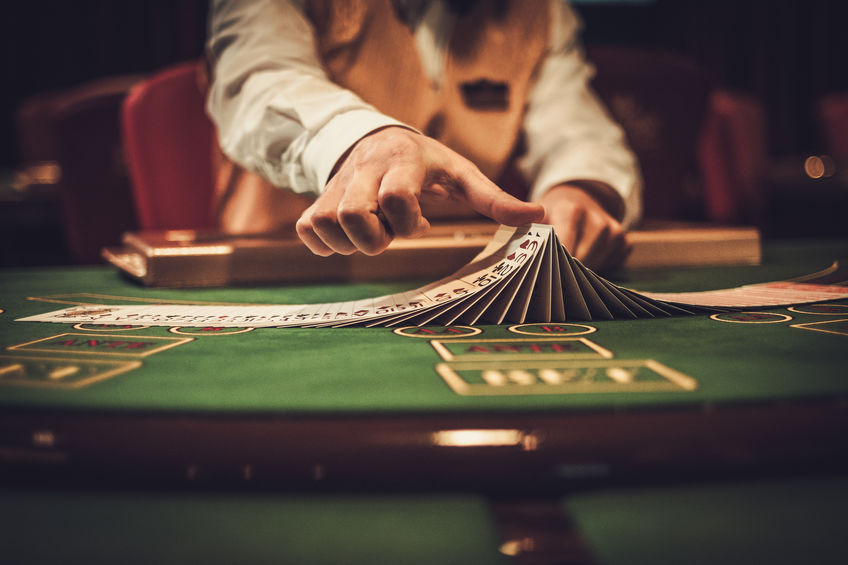 Dealer at table shuffling cards